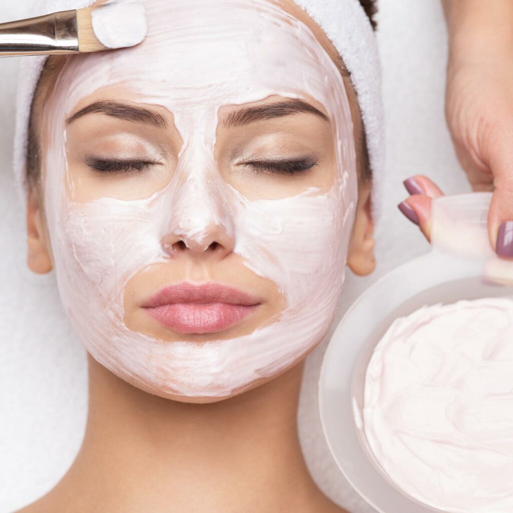 woman receiving facial mask in spa beauty salon